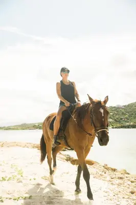 a woman riding a horse on the beach at The Aerial, BVI in Tortola Island
