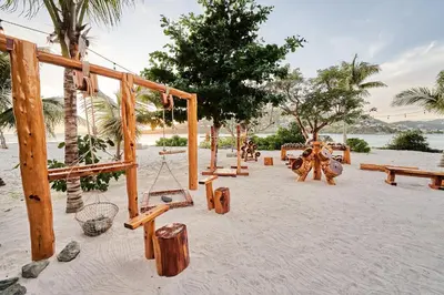 a playground with swings and benches on a beach at The Aerial, BVI in Tortola Island