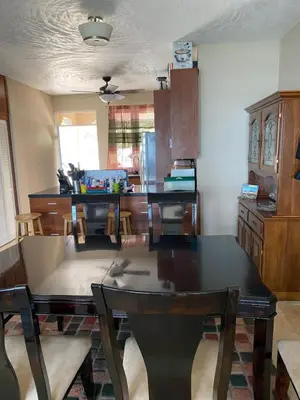a dining room with a table and a kitchen at Top of the Hill Blue Sunshine in Long Swamp