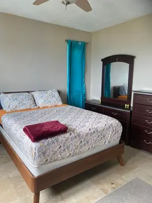 a bedroom with a bed with a dresser and a mirror at Top of the Hill Blue Sunshine in Long Swamp