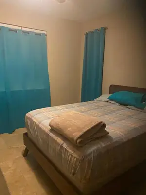 a bedroom with a bed with blue curtains at Top of the Hill Blue Sunshine in Long Swamp