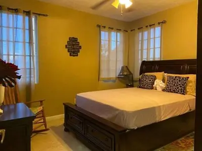 a bedroom with a large bed in a room with windows at SummervilleBVI in Great Mountain