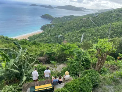 a group of people standing on a hill looking at the ocean at SummervilleBVI in Great Mountain