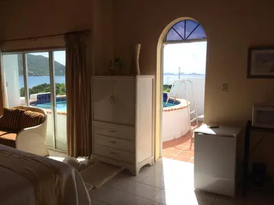 a bedroom with a bed and a tub and a window at Fort Burt Hotel in Road Town