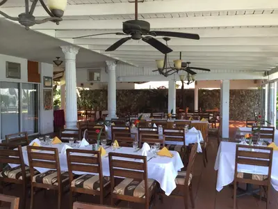 a dining room with white tables and wooden chairs at Fort Burt Hotel in Road Town
