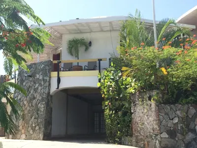 a house with a balcony and a stone wall at Fort Burt Hotel in Road Town