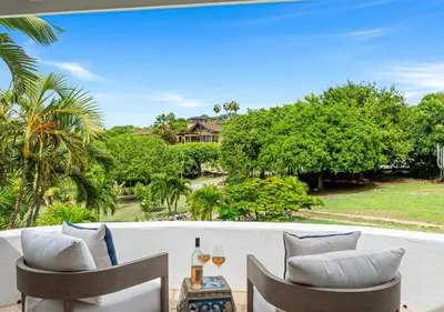 a patio with two chairs and a view of a house at On The Rocks Villa in Spanish Town