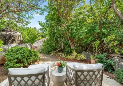 a patio with two chairs and a table at On The Rocks Villa in Spanish Town