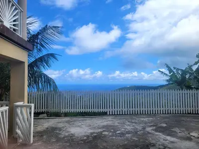 a white fence with the ocean in the background at Sage Mountain Skyway, Comfortable One Bedroom in Sage Mountain, Tortola in Great Carrot Bay