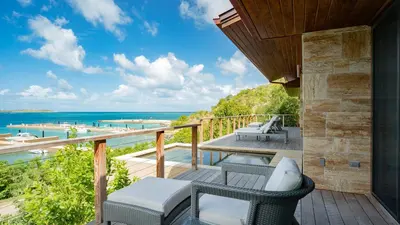 a balcony with chairs and a view of the ocean at Oil Nut Bay in Virgin Gorda
