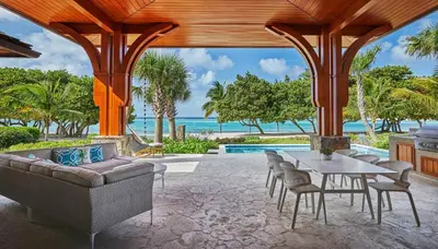 an outdoor living room with a table and chairs at Oil Nut Bay in Virgin Gorda