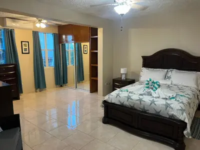 a bedroom with a bed with a blue bow on it at Ocean Breeze Comfort in East End