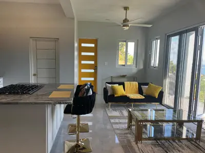 a living room with a couch and a glass table at Exquisitely Threadfall in Cane Garden Bay
