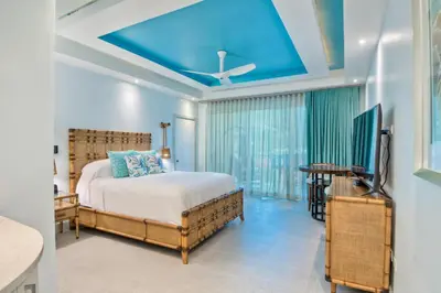 a bedroom with a bed and a blue ceiling at Cane Garden Bay Beach Hotel in Cane Garden Bay