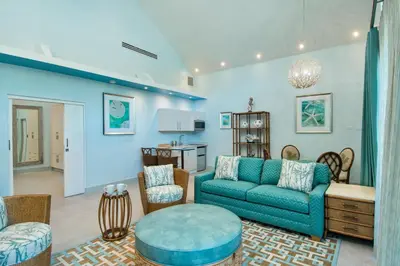 a living room with a blue couch and chairs at Cane Garden Bay Beach Hotel in Cane Garden Bay