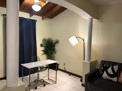 a living room with a table and a blue curtain at JYM Blissful Escape in Tortola Island