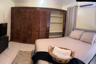 a bedroom with a bed and a cabinet and a television at JYM Blissful Escape in Tortola Island