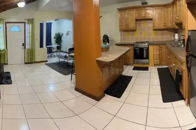 a large kitchen with wooden cabinets and a tile floor at JYM Blissful Escape in Tortola Island