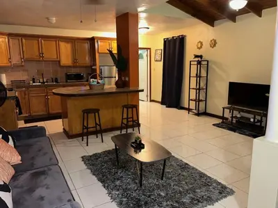 a living room and kitchen with a couch and a table at JYM Blissful Escape in Tortola Island
