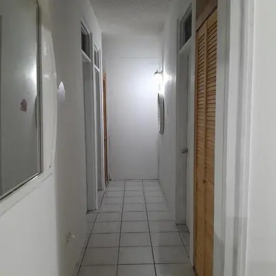 a hallway with a white tile floor and a light at Abigail Diamond 2 bedroom apt Near Nanny Cay marina in Hannah