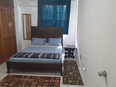 a bedroom with a bed with a blue window at Abigail Diamond 2 bedroom apt Near Nanny Cay marina in Hannah