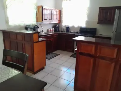 a kitchen with wooden cabinets and a counter top at Abigail Diamond 2 bedroom apt Near Nanny Cay marina in Hannah
