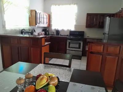 a kitchen with a bowl of fruit on a table at Abigail Diamond 2 bedroom apt Near Nanny Cay marina in Hannah