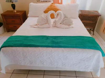 two swans made out of towels sitting on a bed at Sailor's Gem in Tortola Island