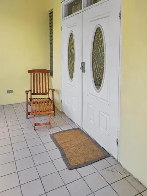 a door with a wooden chair sitting in front of it at Sailor's Gem in Tortola Island