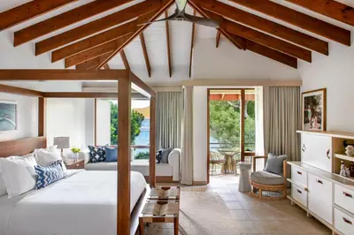 a bedroom with a bed and a living room at Rosewood Little Dix Bay in Virgin Gorda Airport