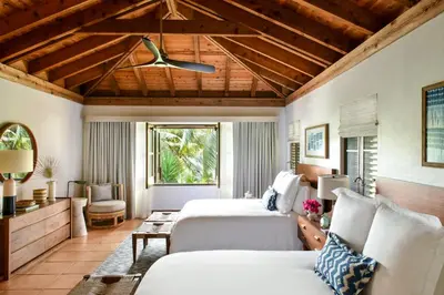 a bedroom with two beds and a ceiling fan at Rosewood Little Dix Bay in Virgin Gorda Airport