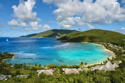 a view of a beach with a boat in the water at Rosewood Little Dix Bay in Virgin Gorda Airport
