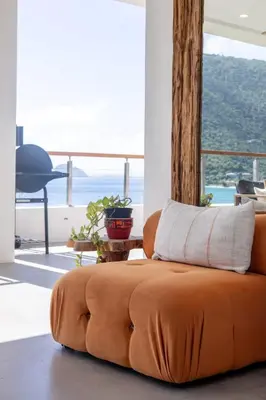 an orange couch sitting in a living room with a window at Cannon Point Estate in Cane Garden Bay