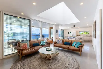 a living room with leather couches and a table at Cannon Point Estate in Cane Garden Bay