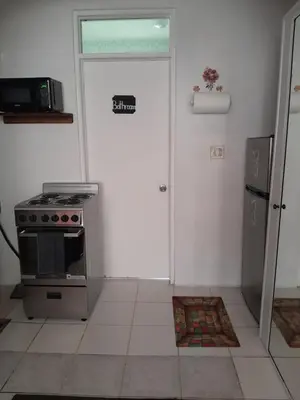 a kitchen with a stove and a door backdoor at Abigail Diamond 1 Bedroom near Nanny Cay Marina in Tortola Island