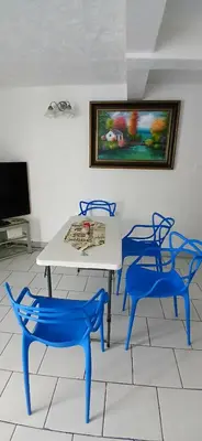 a table and two blue chairs in a room at Beach Front Haven, by More Than Beauty Properties in Tortola Island