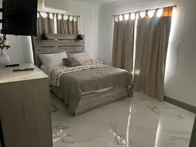a bedroom with a bed and a television in it at Cane Garden Bay 2 bed Apt in Leonards