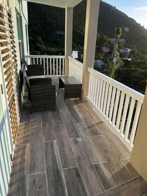 a balcony with chairs and a table and a view at Cane Garden Bay 2 bed Apt in Leonards