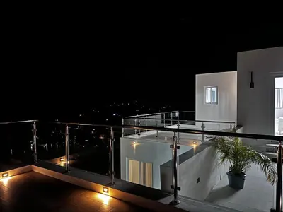 a balcony of a house at night with lights at Zafira Luxe in Road Town