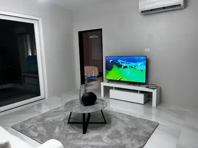 a living room with a television and a table at Zafira Luxe in Road Town