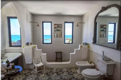 a bathroom with a tub and a sink and a toilet at House of Rogues in Tortola Island