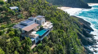 an aerial view of a house on a hill next to the ocean at House of Rogues in Tortola Island
