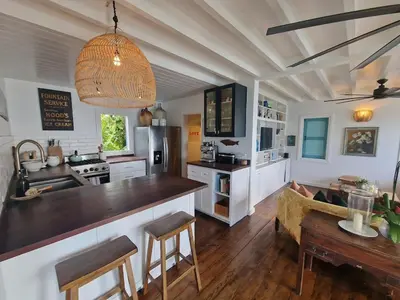 a kitchen with a counter and a table in a room at Lowena Cottage in Tortola Island