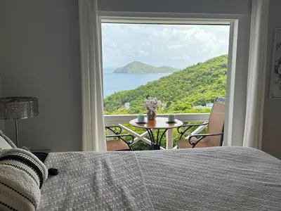 a bedroom with a bed and a view of the ocean at BluEdge Villa VIP Resort Access in Tortola Island