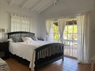 a bedroom with a bed and a large window at BluEdge Villa VIP Resort Access in Tortola Island