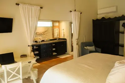 a bedroom with a bed and a desk and a mirror at Endless Summer Villa in Tortola Island