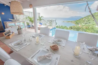 a dining table with a view of the ocean at Endless Summer Villa in Tortola Island