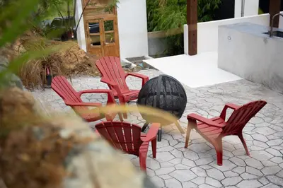 a group of red chairs and a table on a patio at Villa Odyssea BVI in Tortola Island