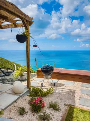 a barbecue grill on a patio overlooking the ocean at Villa Odyssea BVI in Tortola Island