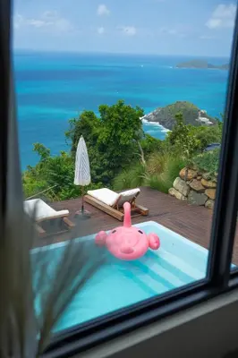 a view of a pool with a toy in a window at Villa Odyssea BVI in Tortola Island